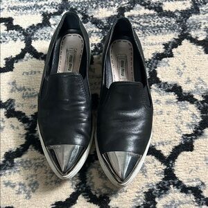 Miu Miu Black Leather Slip-Ons with Metallic Silver Toe